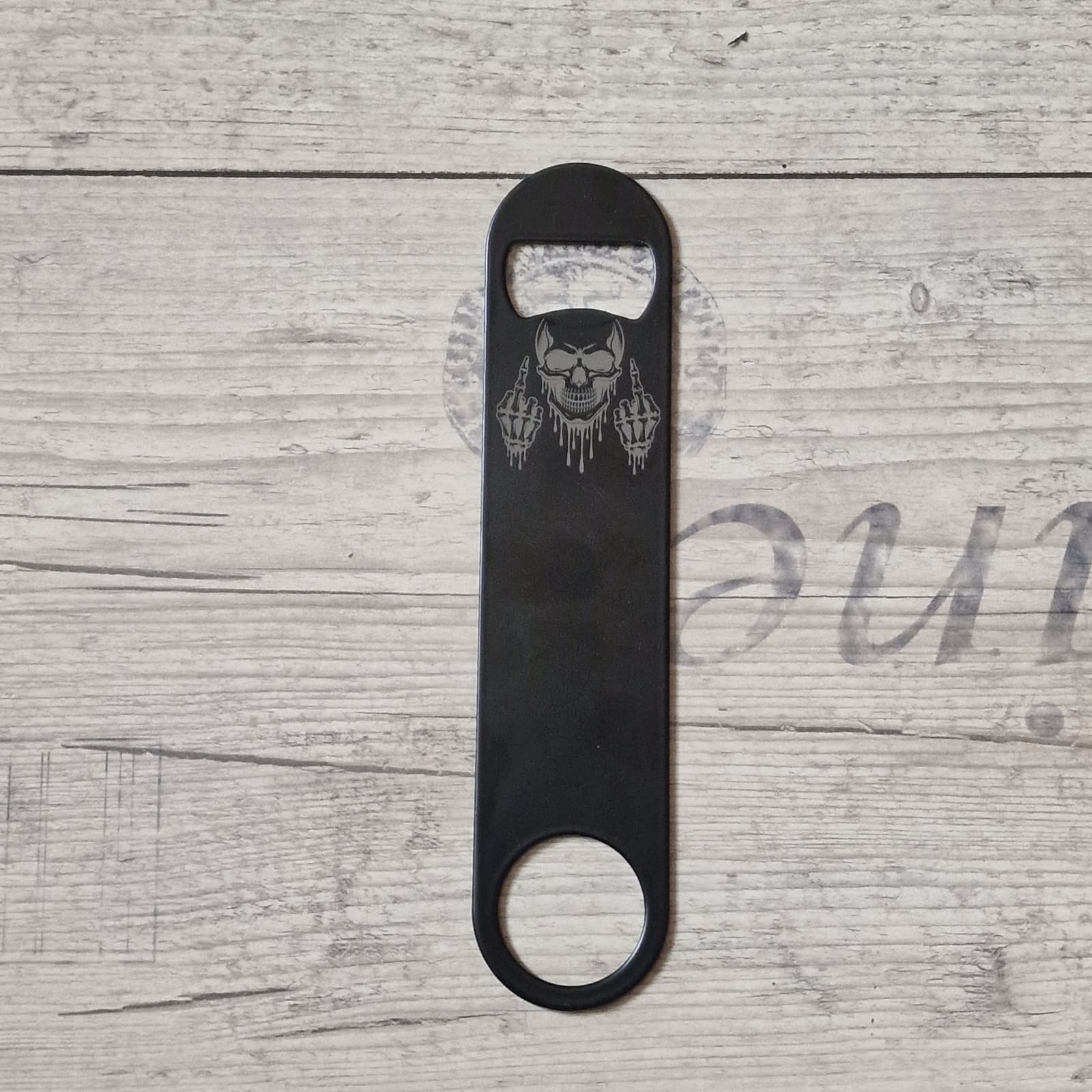 Lasergravur auf schwarzem Flaschenöffner mit Totenkopf-Motiv